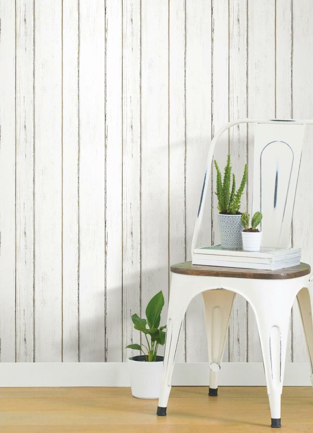 White lined shiplap peel and stick wallpaper with rustic texture in home decor setting featuring chair and small plants
