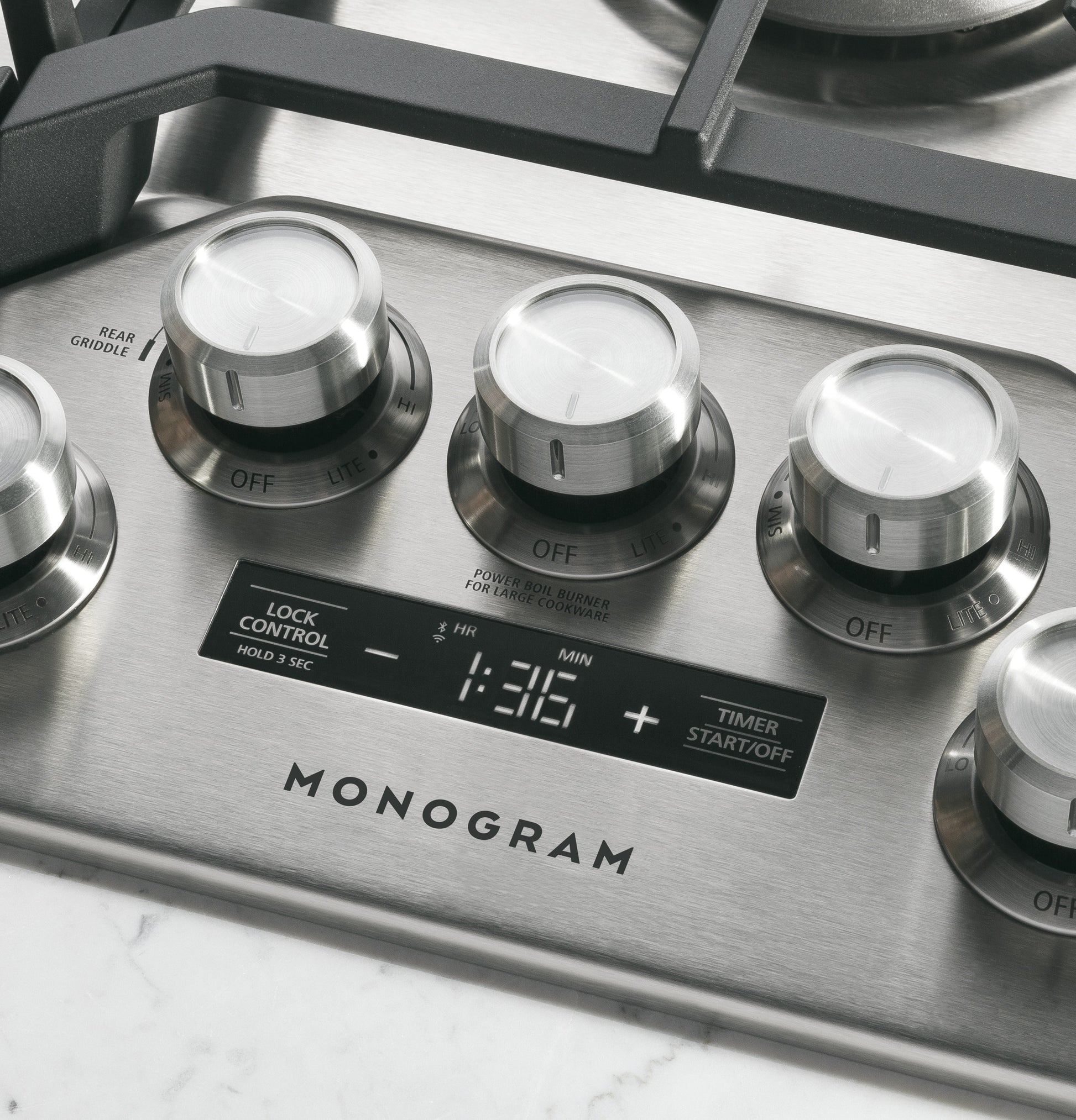 Close-up of stainless steel cooktop control knobs and digital timer on Monogram gas cooktop in Kitchen & Kitchenware collections