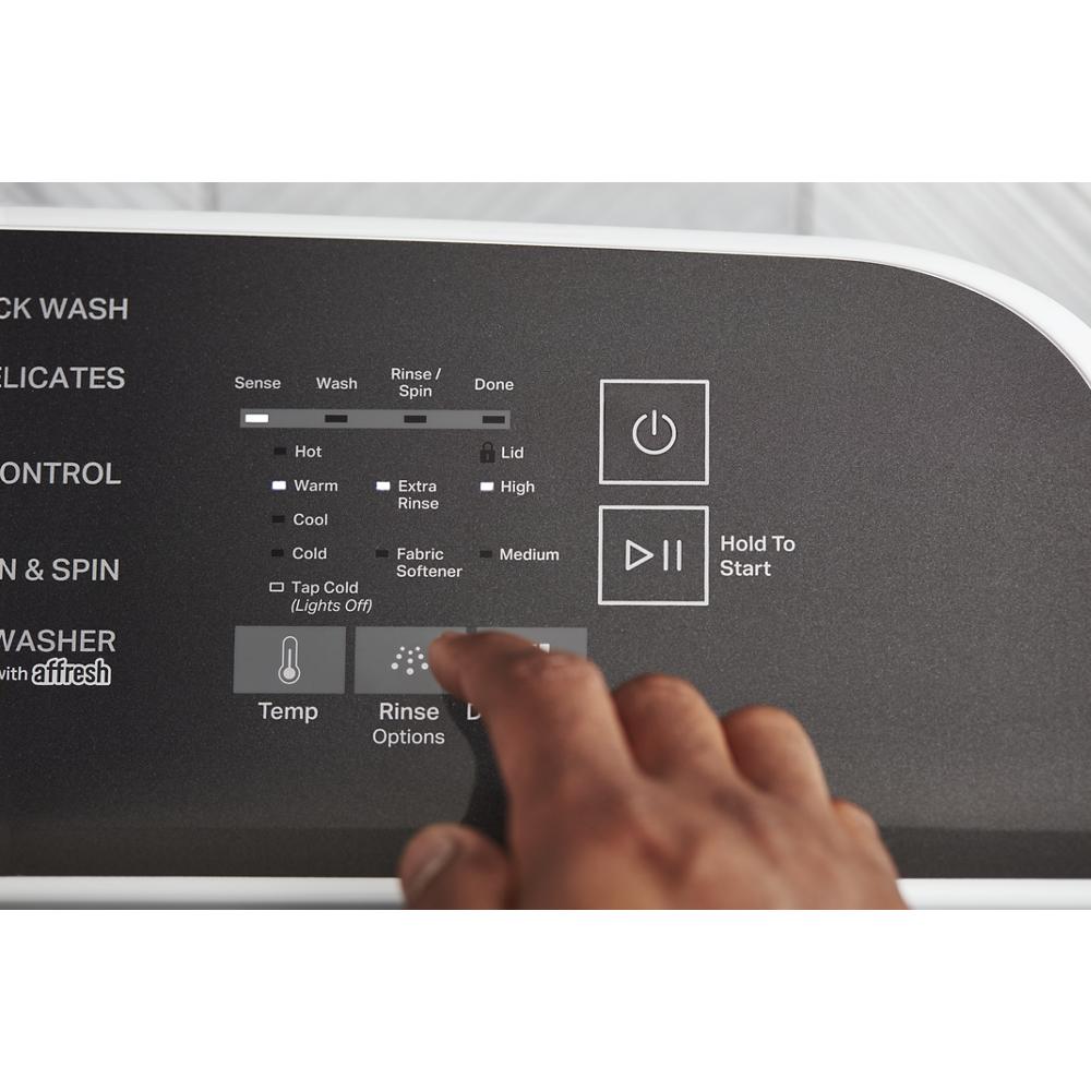 Close-up of hand selecting rinse options on black control panel of laundry appliance in washers and dryers collection