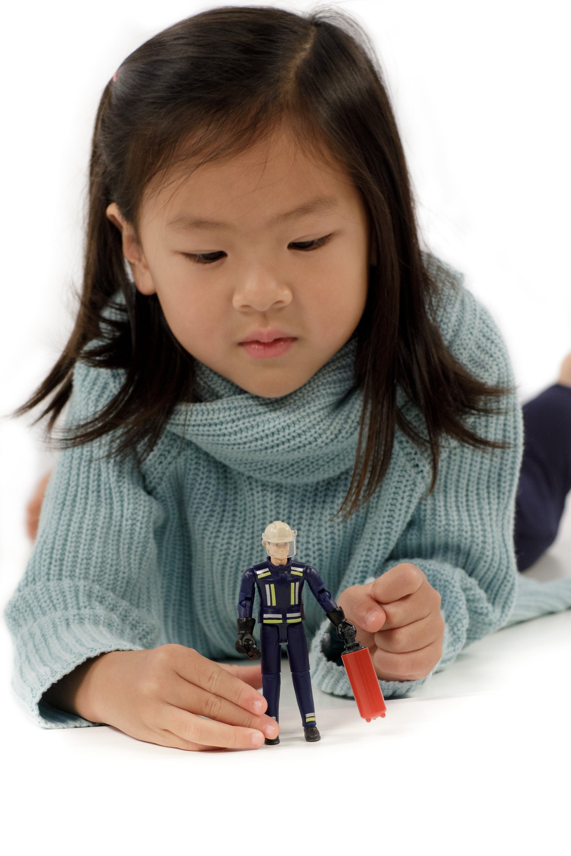 Young child playing with detailed 1:16 scale bWorld fireman figure and accessories from Bruder Toys collection