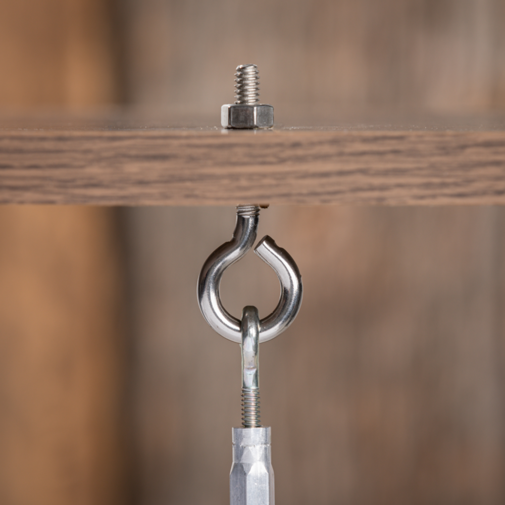 Stainless steel eye bolt with threaded shaft and hex nut fastened in wood for hardware and home improvement projects