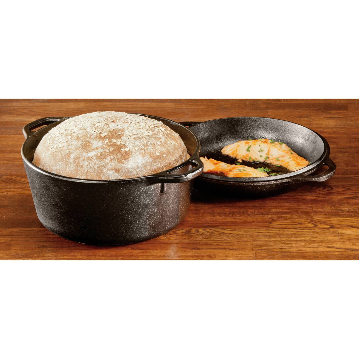 Black cast iron Dutch oven with rising bread dough and seasoned skillet with cooked salmon in kitchenware collections under $100
