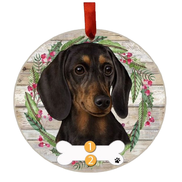 Round Christmas ornament featuring a black dachshund face with festive wreath and red ribbon for hanging