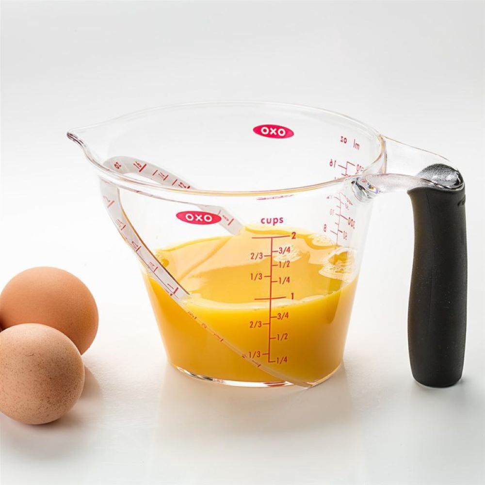 Clear angled measuring cup with black handle and red measurement markings for accurate liquid measuring in cooking tasks