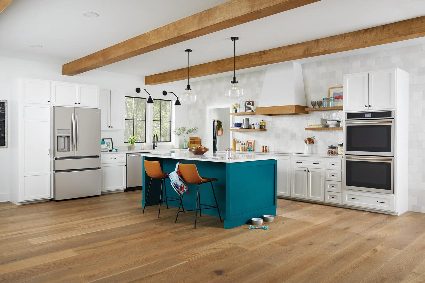 Modern kitchen with white cabinetry, teal island with seating, and stainless steel double wall oven from Appliances collection