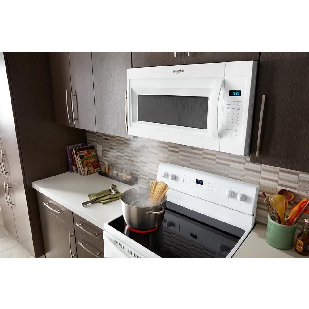 White over the range microwave with digital display and control panel installed above a stovetop in kitchen appliances collection