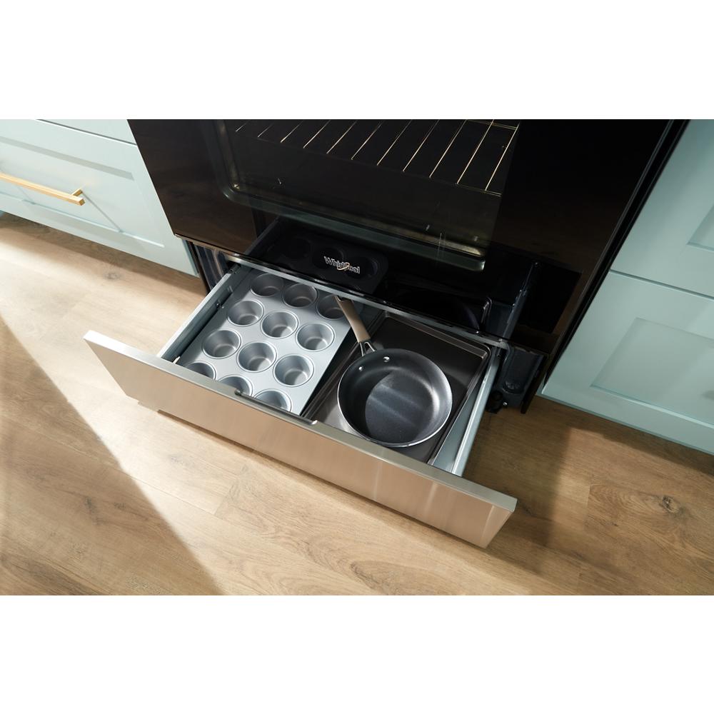 Open warming drawer under 30-inch gas range showing metal bakeware and frying pan in kitchen setting