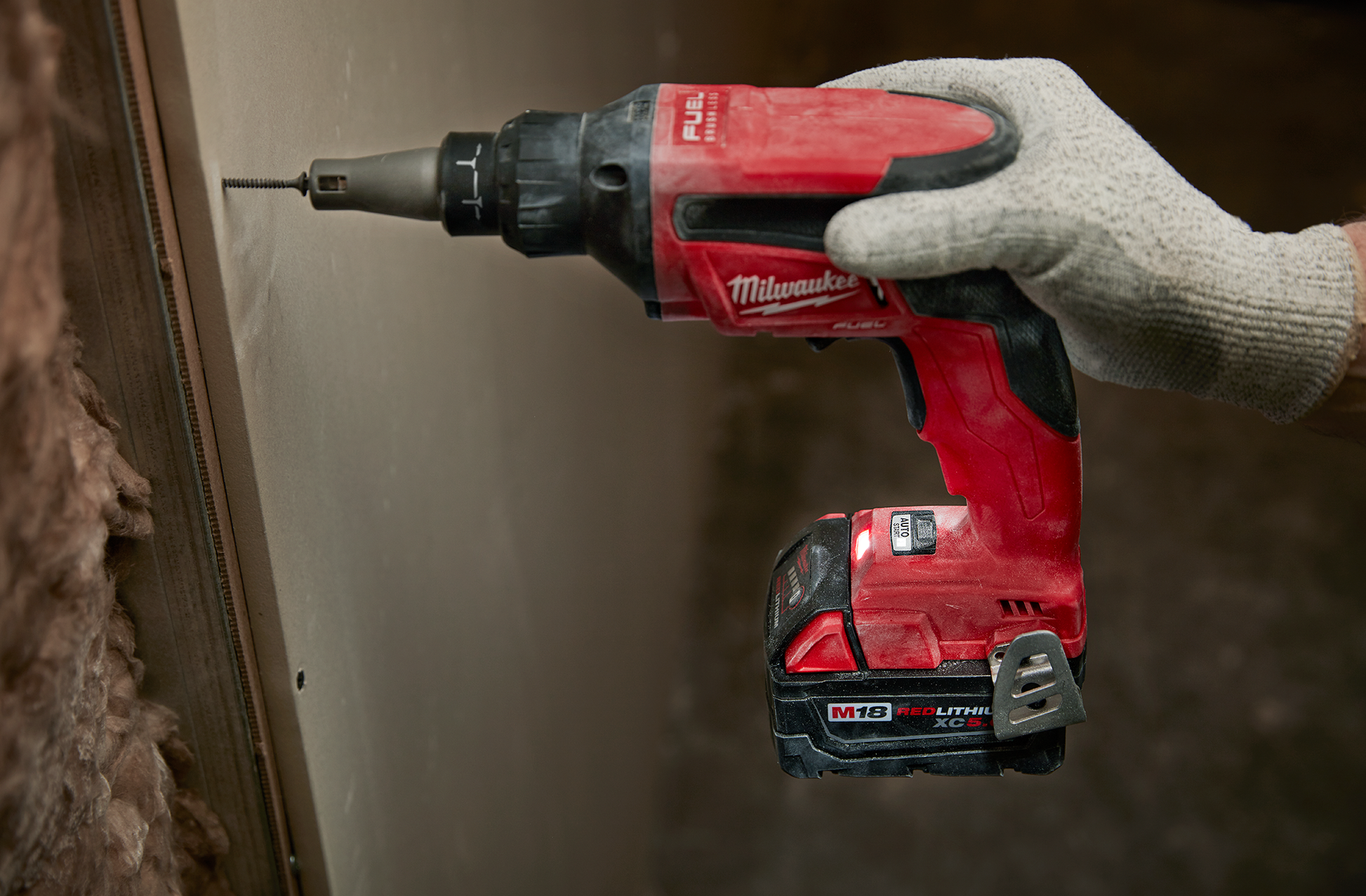 Red cordless drywall screw gun with brushless motor being used on drywall in woodworking tools collection