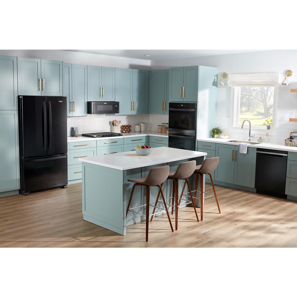 Bright kitchen with mint green cabinetry, black double wall oven, refrigerator, and matching dishwasher with center island seating