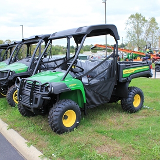 Green John Deere HPX615E utility vehicle with heavy-duty tires and protective canopy for versatile outdoor work tasks