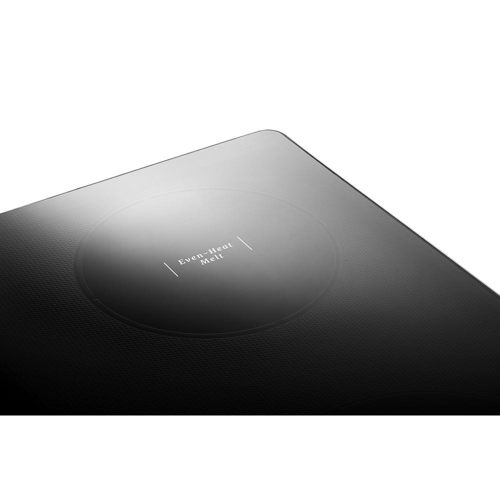 Close-up of black glass cooktop surface highlighting the Even-Heat Melt element from Kitchen & Kitchenware collection