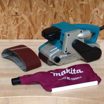 Teal and silver corded belt sander with removable maroon dust bag and sanding belt for home improvement projects