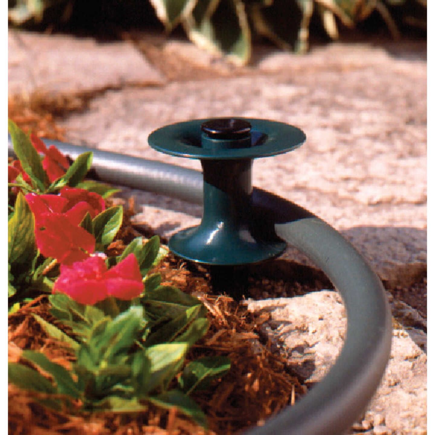 Black plastic hose guide with stake protecting flower bed from garden hose in lawn and garden watering tools collection