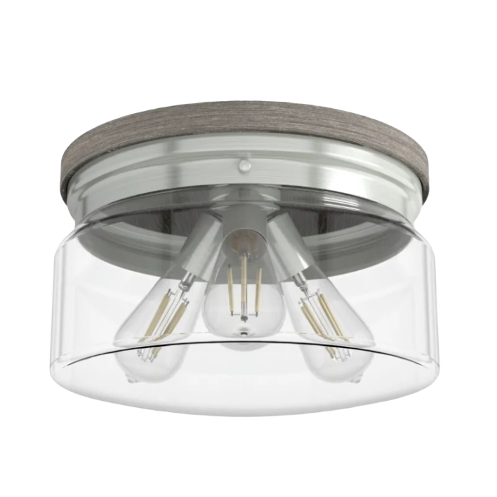 Three-light flush mount with brushed nickel finish, grey wood accents, and clear glass shade for bathroom lighting
