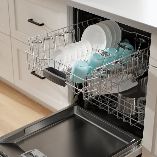 Open white 24-inch dishwasher loaded with clean plates, glasses, and bowls in modern kitchen setting