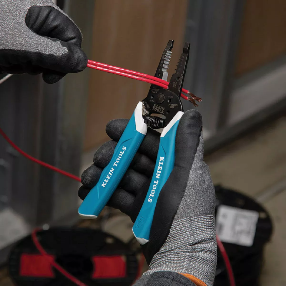 Blue-handled wire stripper by Klein with dual cutting slots for solid and stranded wires in home improvement tasks