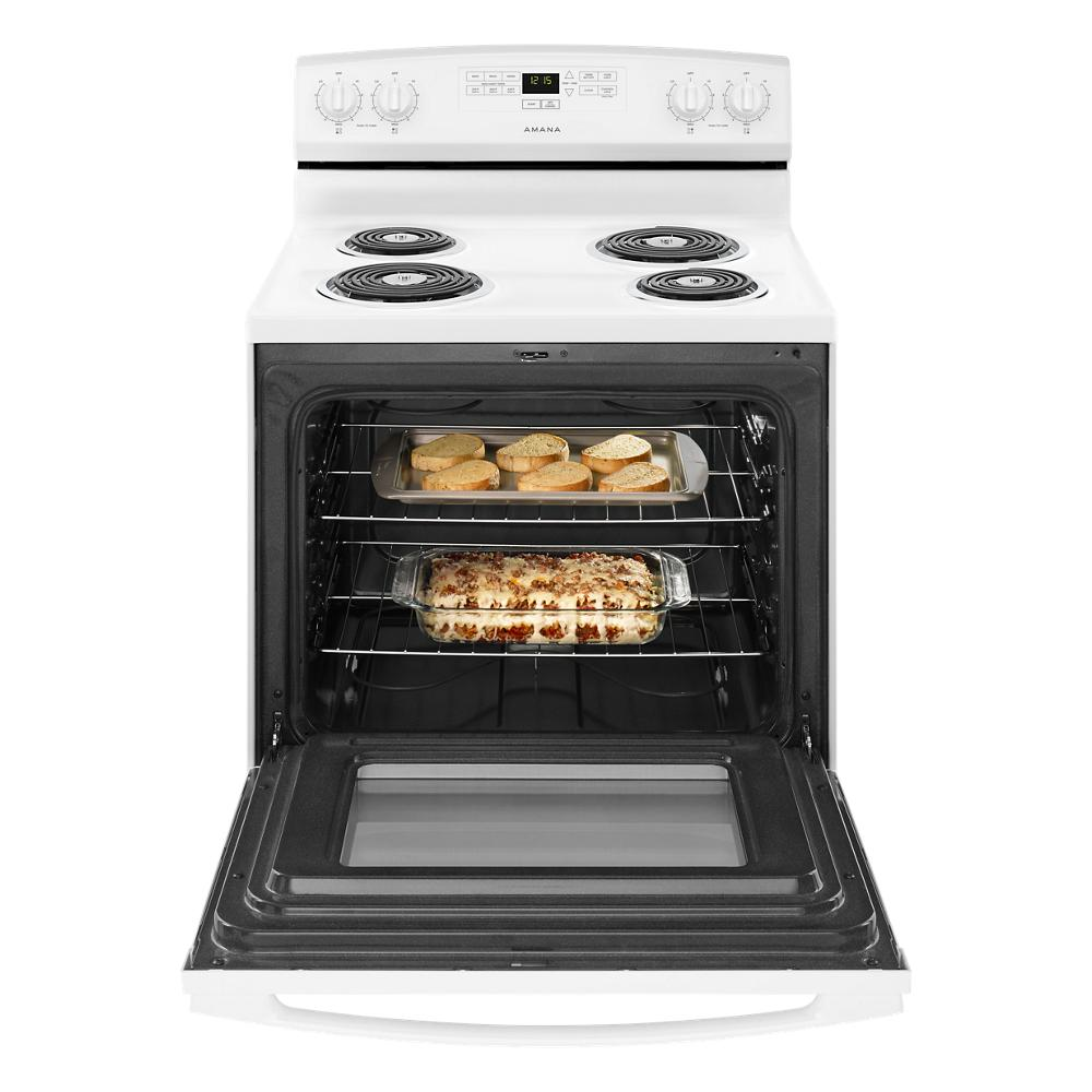 Open white electric range oven with baked casserole and bread inside from kitchenware appliance collection