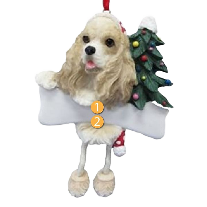 Cocker Spaniel dog ornament with dangling legs holding a white bone and a decorated Christmas tree behind