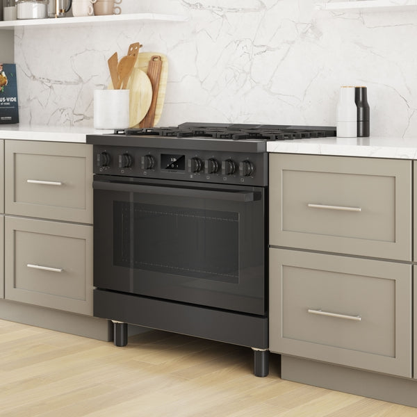 Black stainless steel 36-inch gas freestanding range installed between gray kitchen cabinetry with metal handles