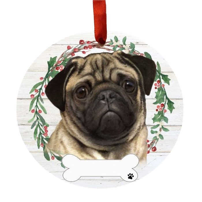 Round ornament featuring a smiling pug face inside a festive holly wreath with red berries and green leaves hanging by red ribbon