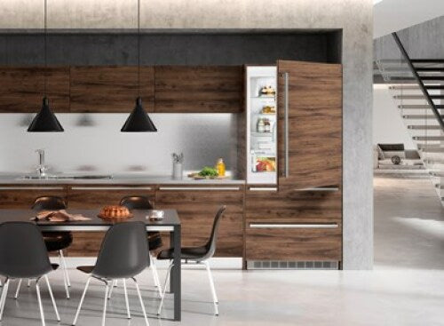 Modern kitchen with built-in refrigerator/freezer featuring wood panel doors, open fridge, and dining table in Appliances collection