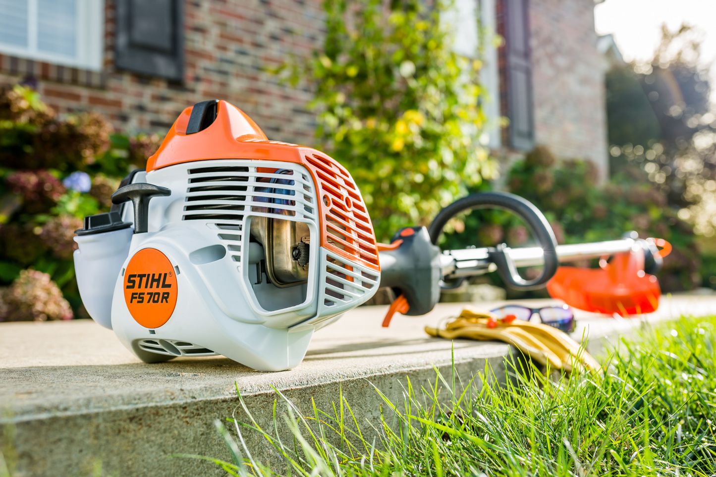 Orange and white gas-powered string trimmer with straight shaft designed for outdoor lawn and garden care tasks