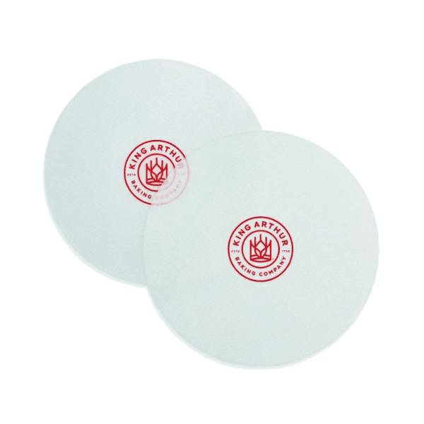 Two white round cake pan liners with red logo for baking and kitchen use in a 2-pack set