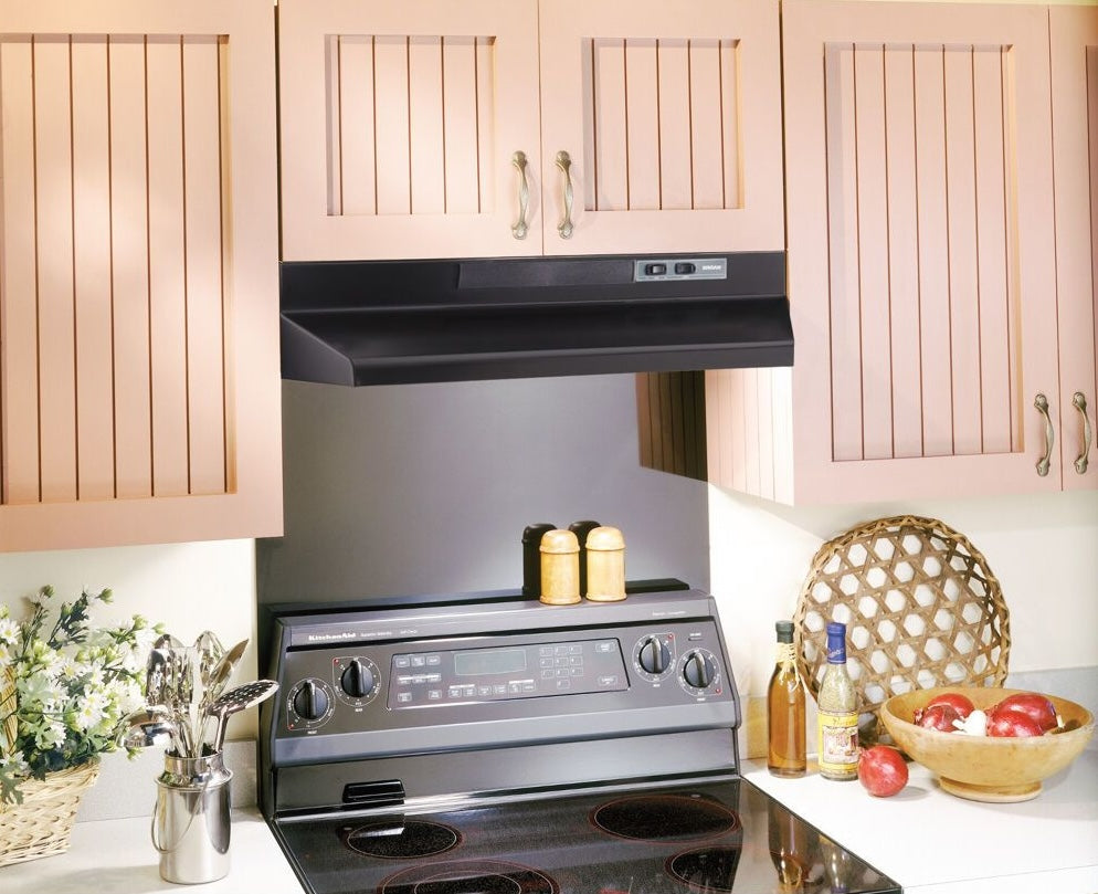 Black under-cabinet range hood installed above electric stove in kitchen with beige cabinetry and countertop accessories in Appliances collection