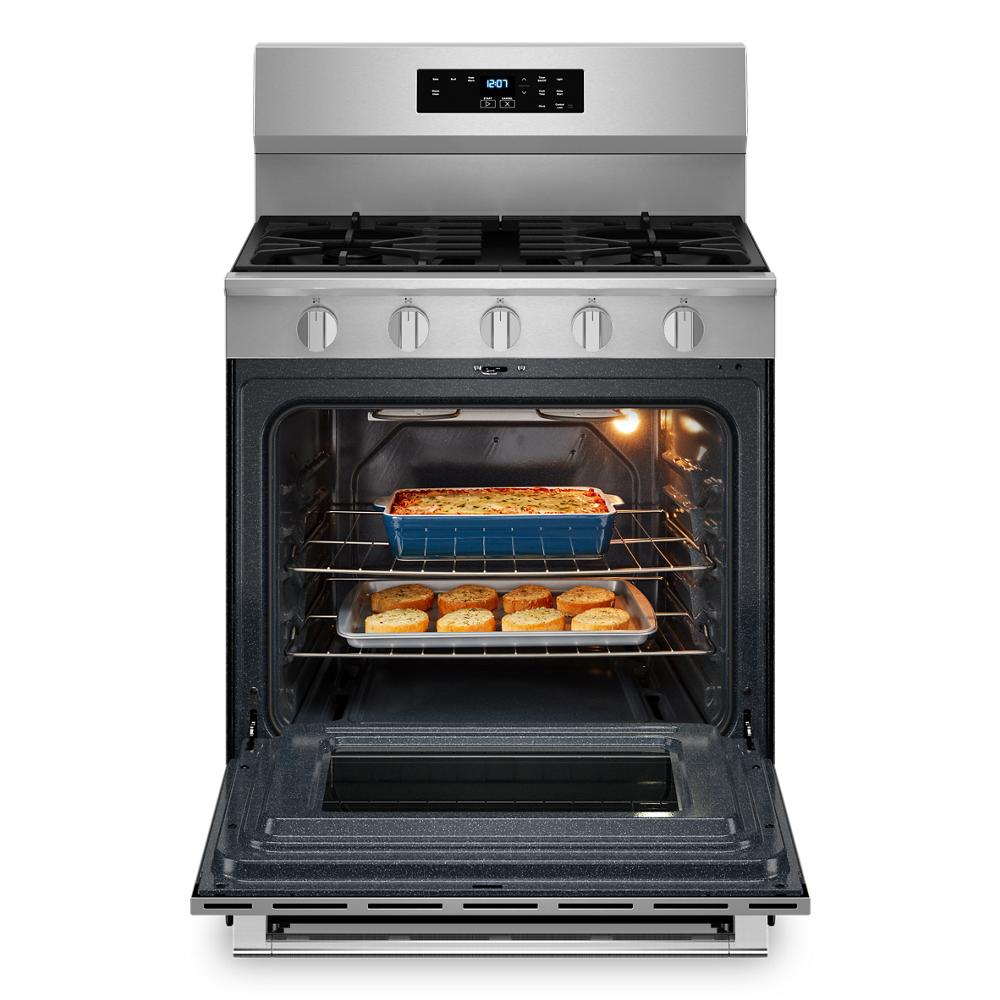 Open stainless steel gas range with two trays of baked food inside and control panel on backguard from Ranges collection
