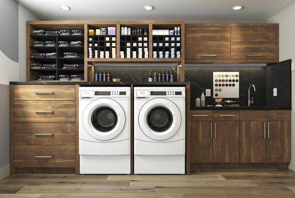 White front-load washer and dryer set integrated into modern wooden laundry room cabinetry and shelving from appliances collection