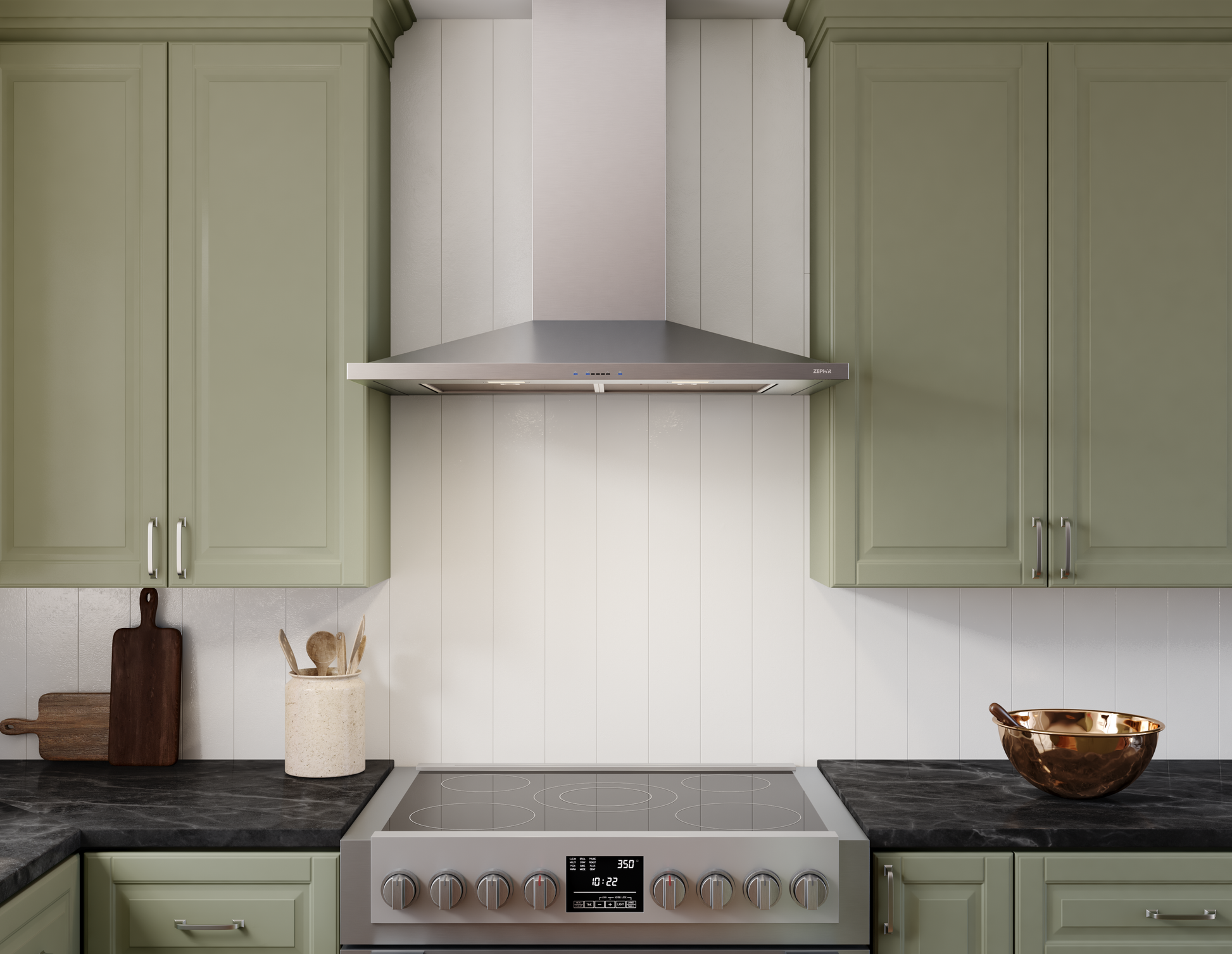 Stainless steel chimney-style range hood mounted above electric stove in kitchen with green cabinetry and black counters