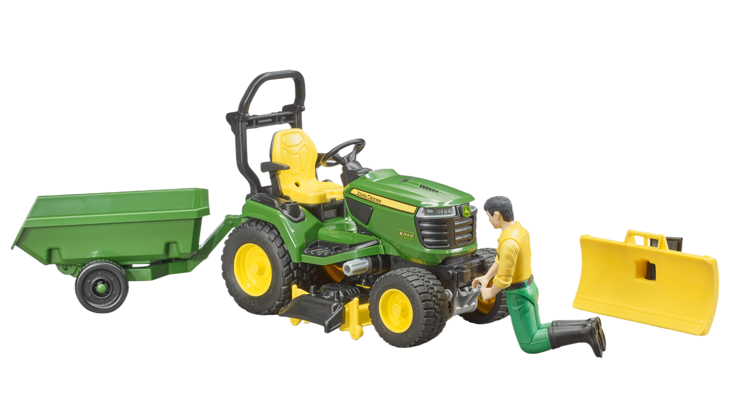 Green and yellow John Deere lawn tractor toy with attached trailer, operator figure, and separate front blade for outdoor power equipment collections