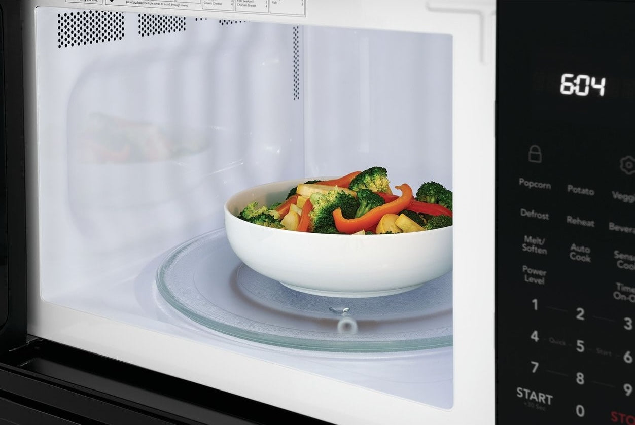 White bowl with cooked mixed vegetables inside a microwave oven from Kitchen & Kitchenware collection