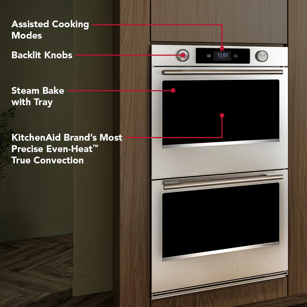 Built-in double wall oven in stainless steel with backlit knobs, touchscreen, and steam bake feature in modern kitchen setup