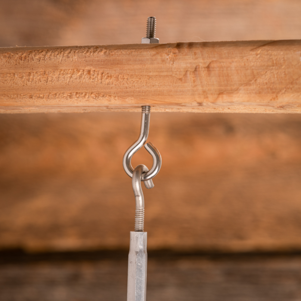 Stainless steel eye bolt with hex nut securing metal hook to wood beam for hardware and home improvement tools under $50