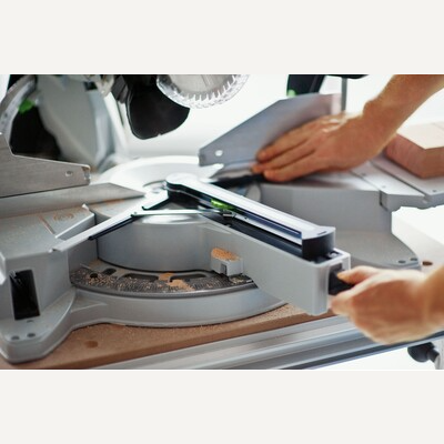 User adjusting the angle mechanism on a Festool miter saw for precise cuts in power tools and home improvement collections