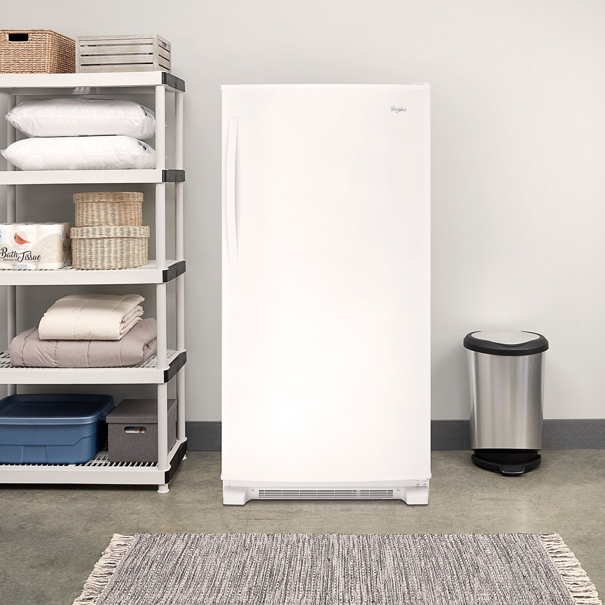 White upright freezer with recessed handle, temperature alarm, and front ventilation grille in kitchen appliances setting