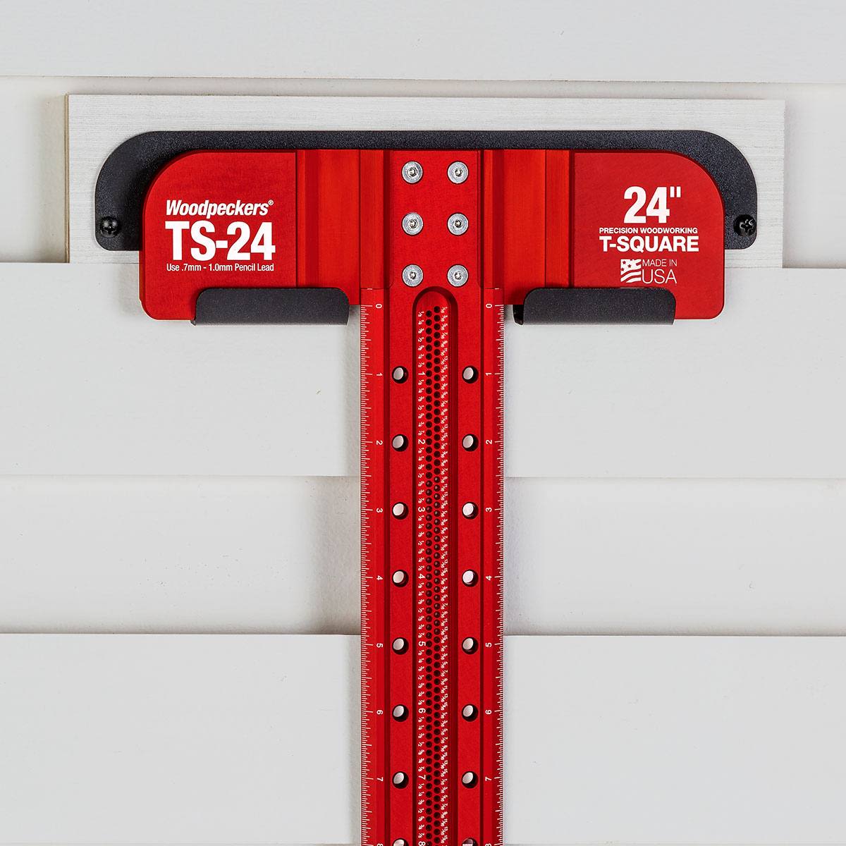 Red 24-inch precision T-square with black lip resting on white surface in woodworking and measuring tools collections