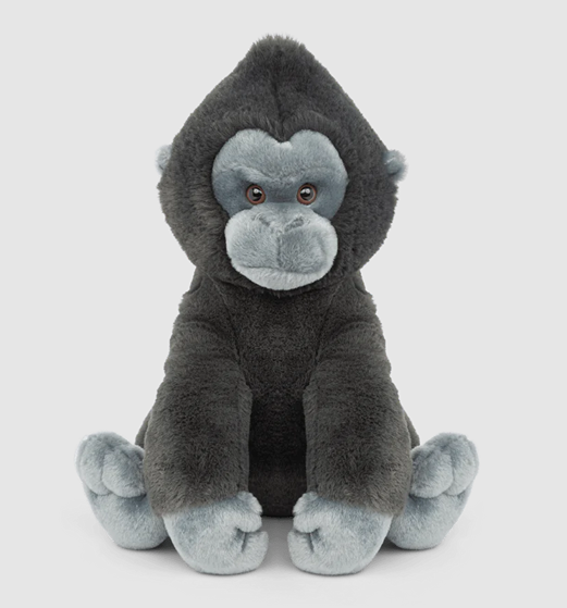 Soft plush gorilla with dark and light gray fur sitting upright on a plain light background