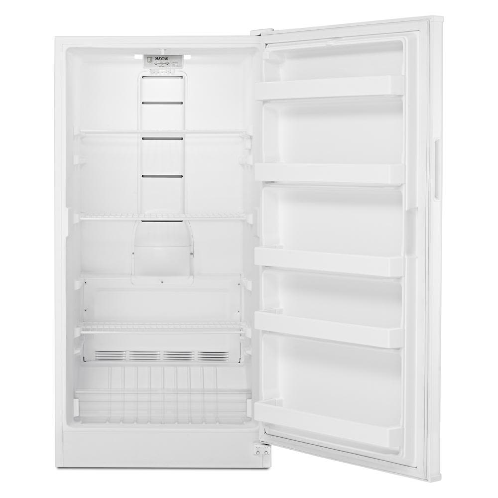 Empty white upright freezer interior with multiple shelves and door compartments in kitchen appliance setting