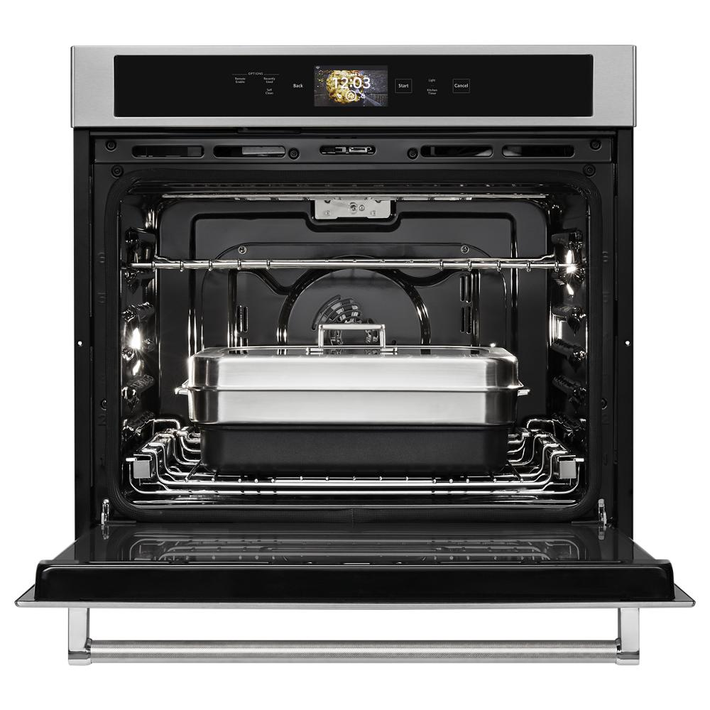 Open stainless steel single oven with digital display and powered attachments in modern kitchen appliance collection