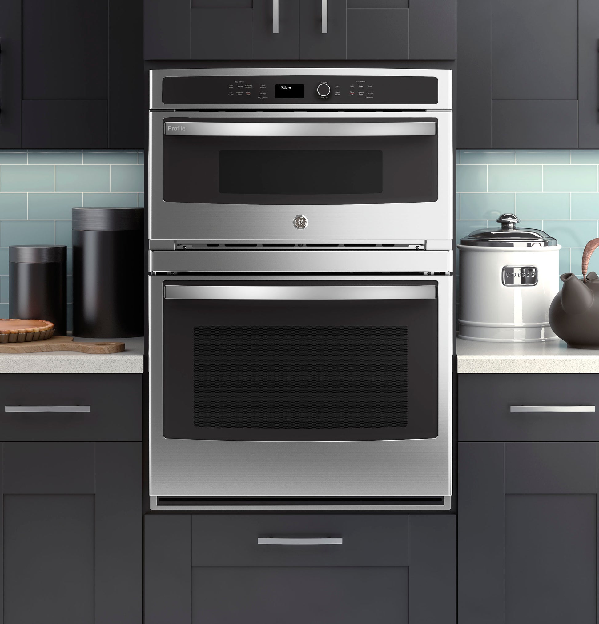 Stainless steel built-in combination convection microwave and wall oven in modern kitchen with dark cabinetry and light backsplash
