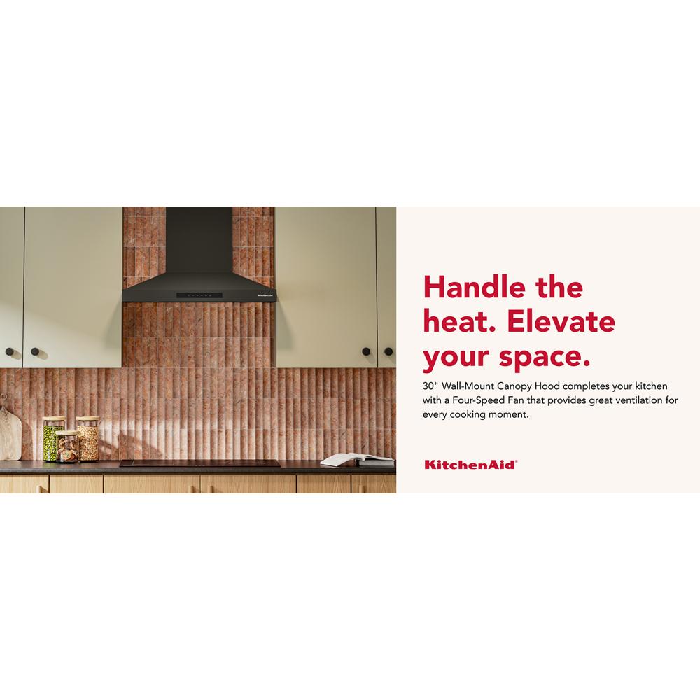 Matte black 30-inch wall-mount canopy hood with four-speed fan in kitchen featuring textured brick backsplash and light cabinetry