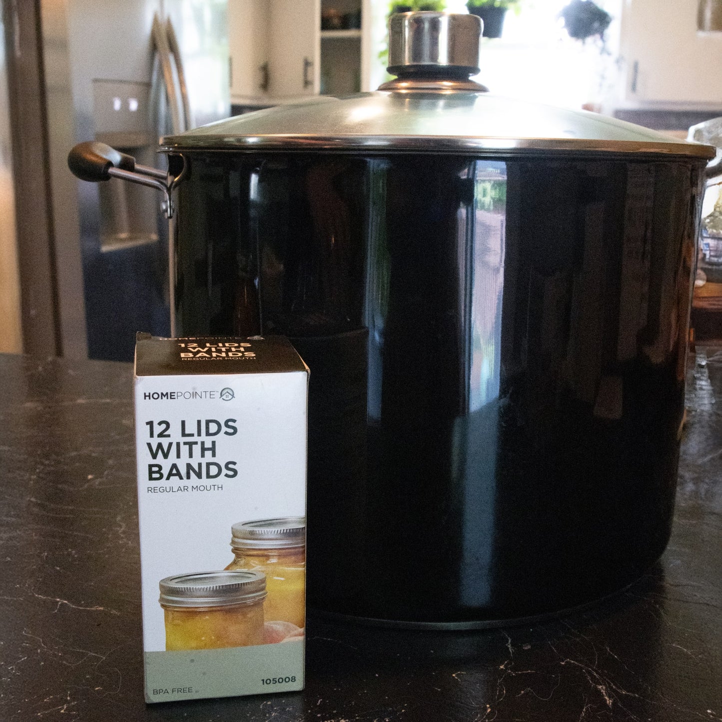 Box of 12 regular-mouth lids and bands next to large black cooking pot in kitchenware collection under $50