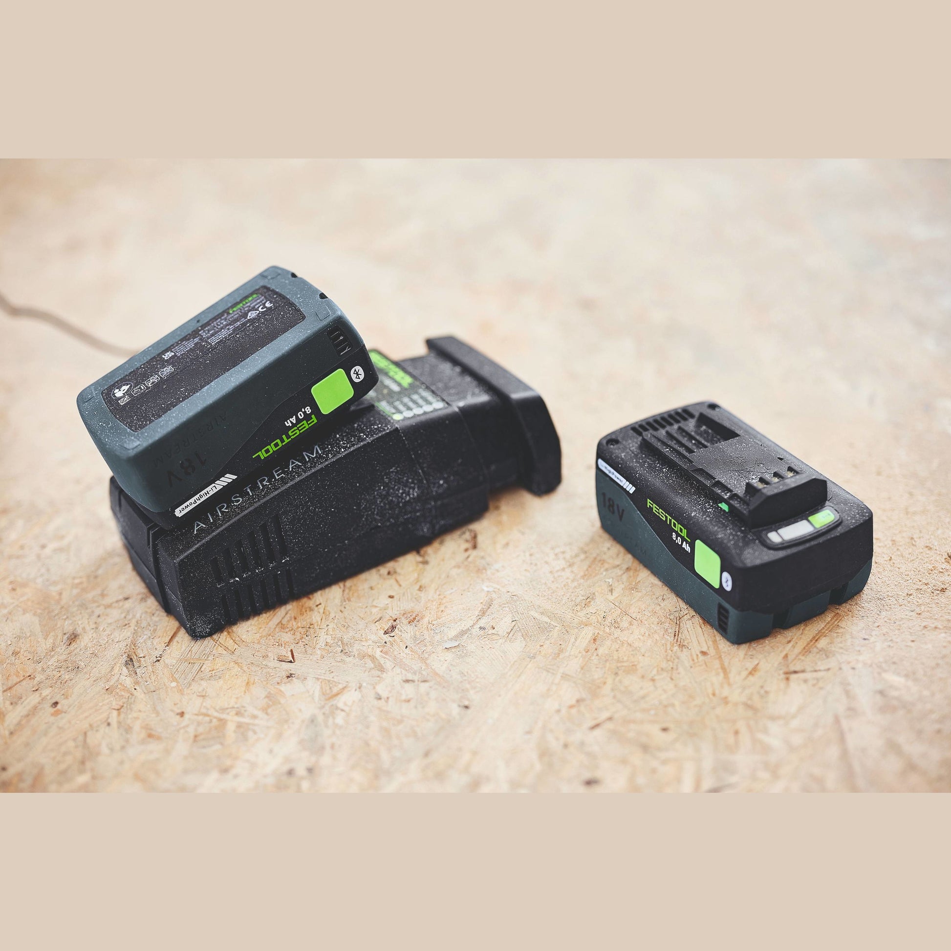 Two compact rechargeable Festool 18V battery packs with 8.0 Ah capacity on a wood surface for tools and home improvement tasks
