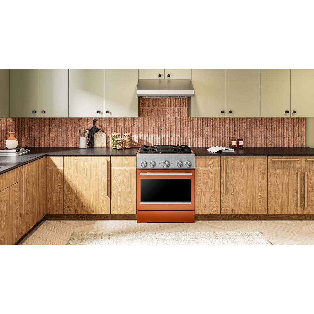 Orange and stainless steel dual fuel range with four burners and stainless steel hood in modern kitchen setting