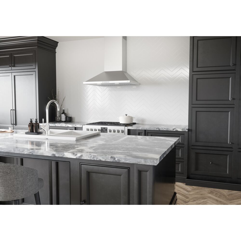 Wall mounted pyramid-shaped stainless steel chimney hood with LED lights in modern kitchen and appliance collection