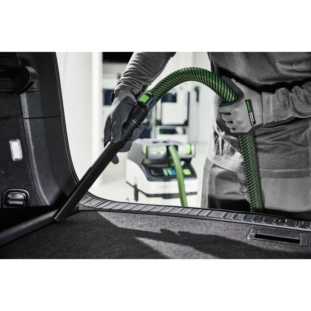 Vacuum crevice nozzle attached to green hose used for precise cleaning in dust management and shop vacuum accessories collections