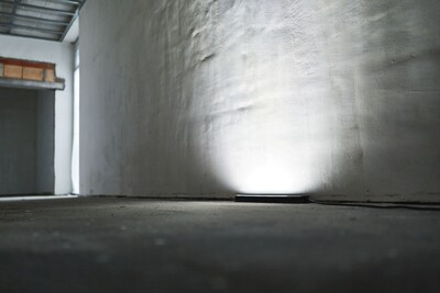 Slim circular surface control light casting bright, even illumination on textured wall in a work light and tools setting