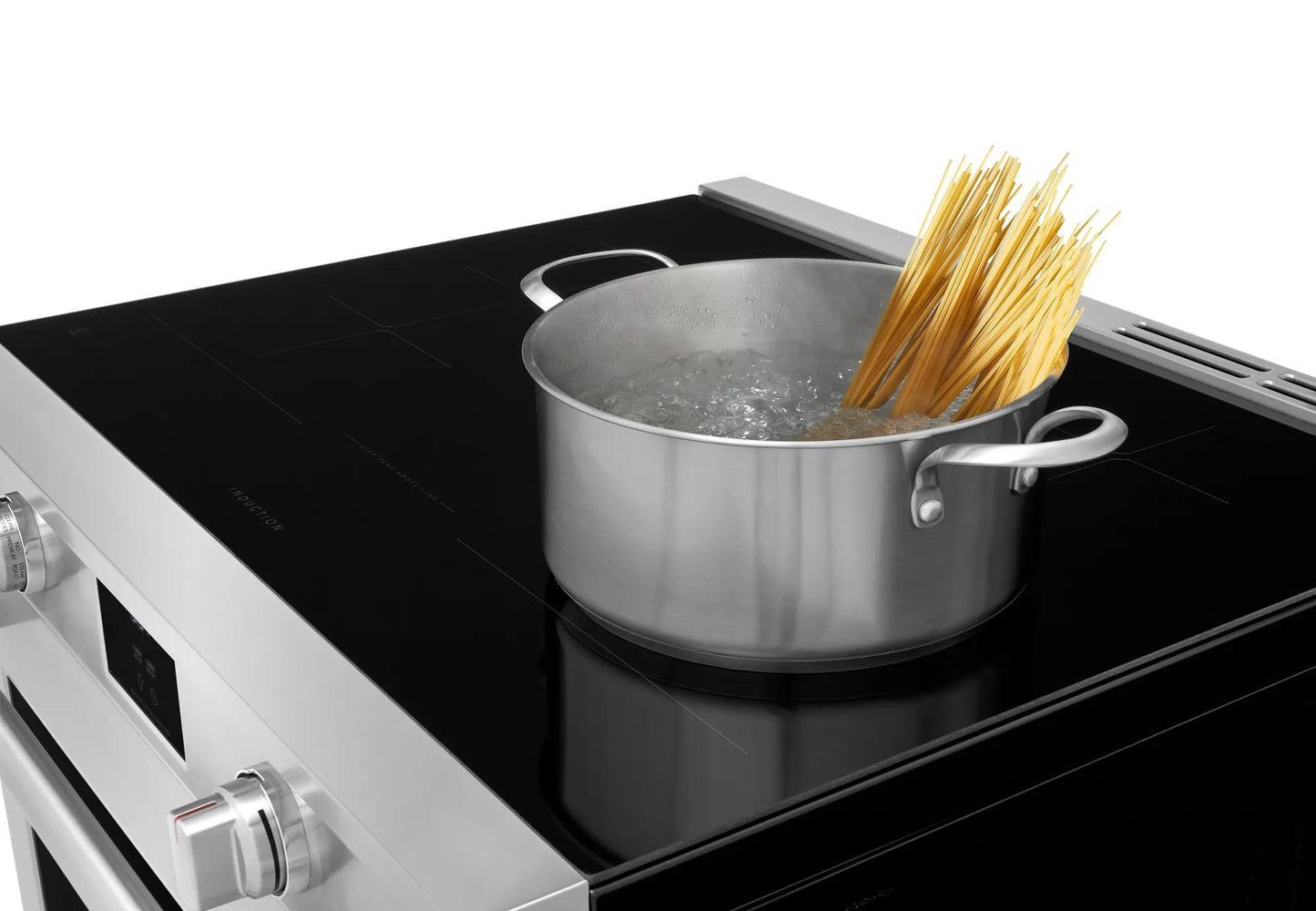 Stainless steel pot boiling pasta on black induction cooktop from modern kitchen appliance collection